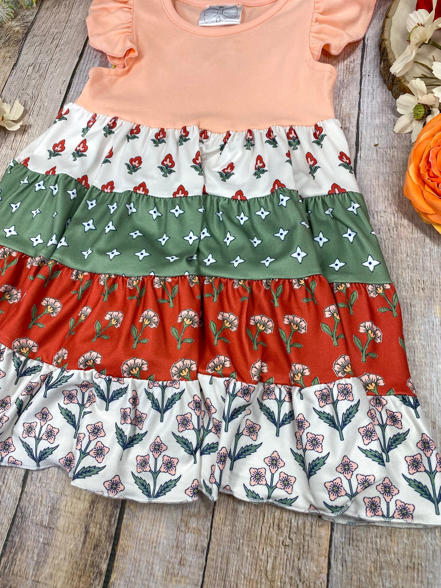 Boho Coral Boutique Girls Tiered Dress on a wooden background