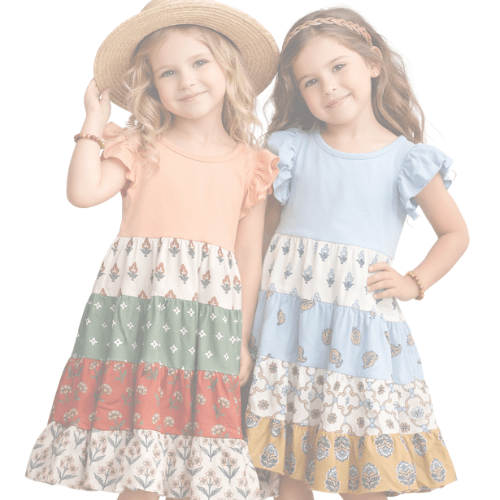 Two young girls wearing colorful patterned dresses on a white background - Alternative view