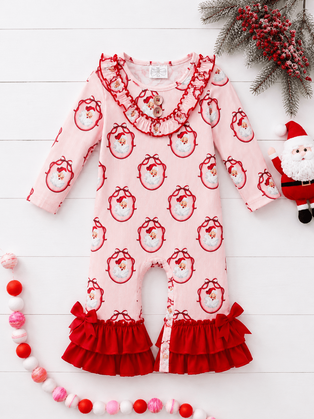 Vintage Santa Christmas infant romper featuring a classic Santa print, layered red ruffles, bows, and festive holiday styling.