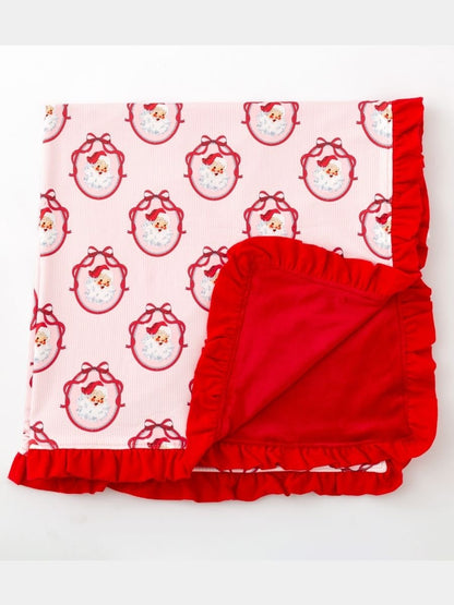 Folded Pink Nutcracker Christmas minky baby blanket featuring a vintage Santa print, red plush minky backing, and ruffle edge.