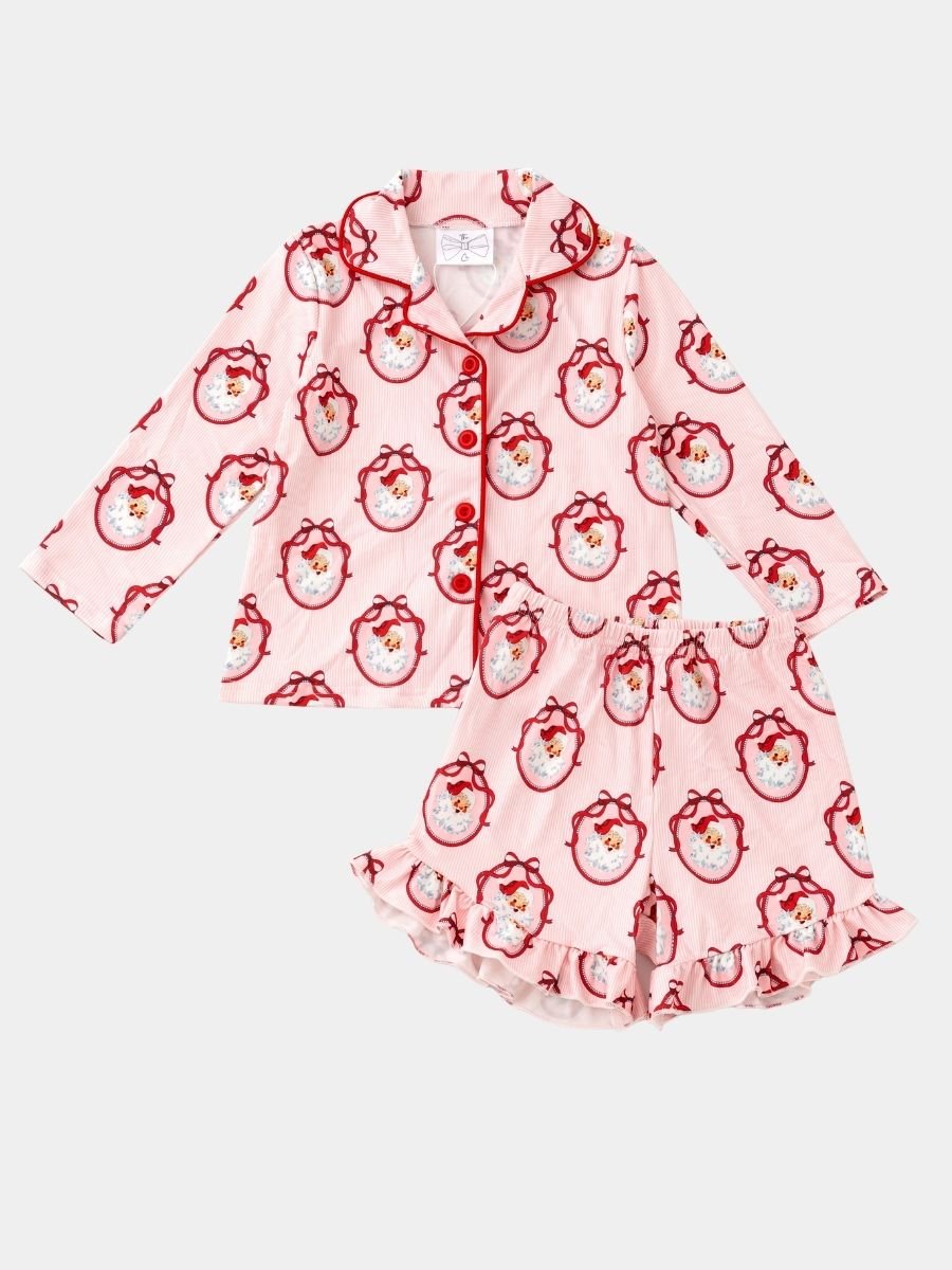 Girls Vintage Santa Christmas pajama set featuring a classic Santa print, button-front top, and ruffle shorts.