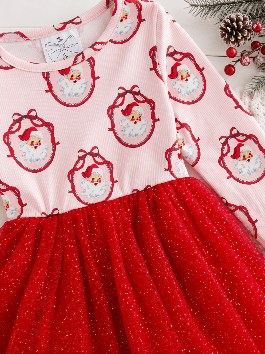 Close-up of the Vintage Santa Christmas tutu dress featuring classic Santa portrait print, soft pink striped fabric, and a sparkly red tulle skirt.