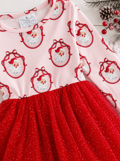 Close-up of the Vintage Santa Christmas tutu dress featuring classic Santa portrait print, soft pink striped fabric, and a sparkly red tulle skirt.