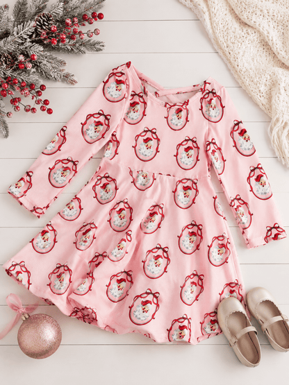 Girls Vintage Santa Christmas twirl dress styled in a festive flatlay with classic Santa print, pink striped fabric, full twirl skirt, and coordinating holiday accessories.