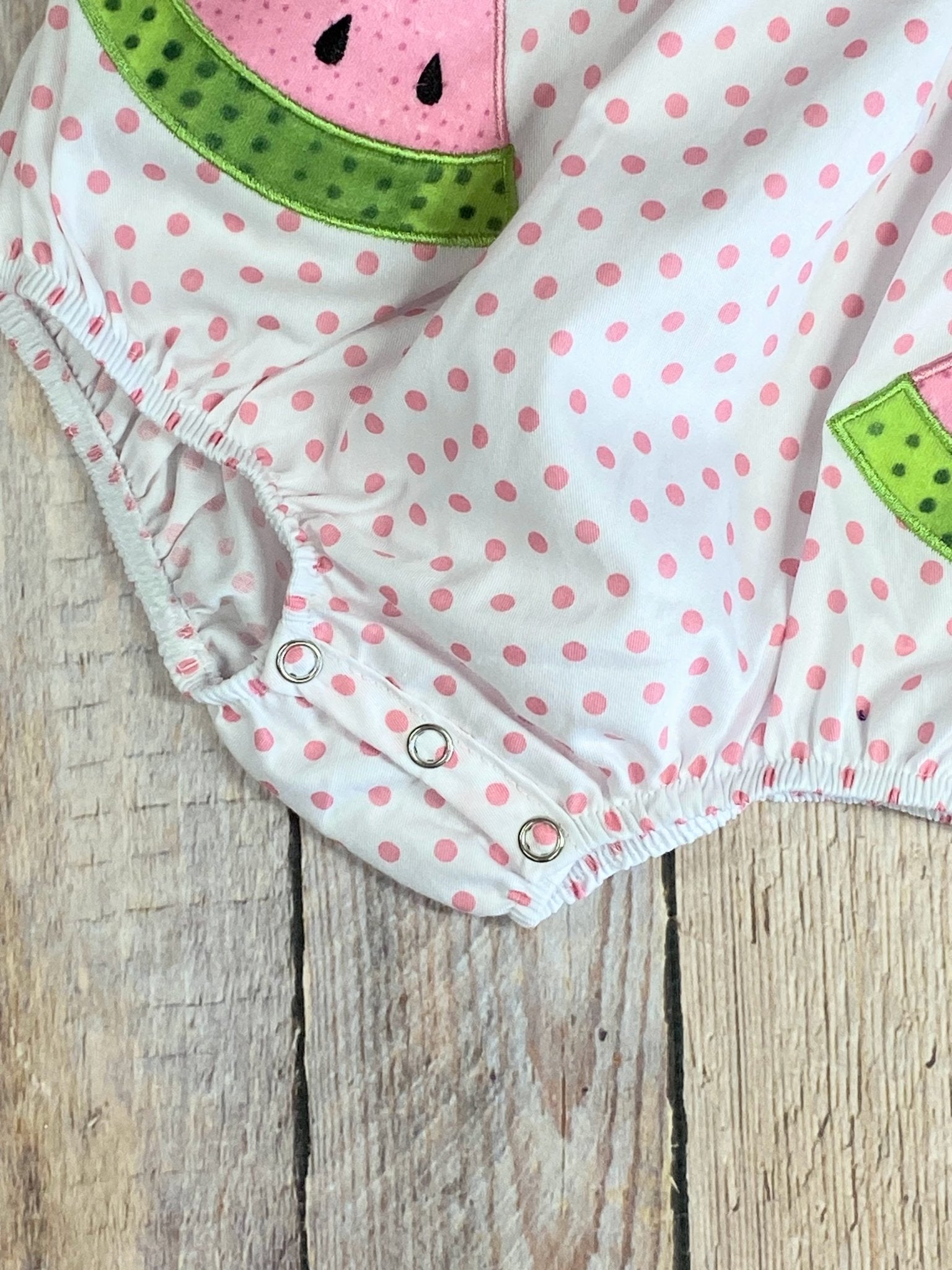 Close up detail photo of the snaps at bottom of romper