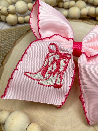 Pink Western Boot Embroidered Moonstitch Hair Bow on a wooden background
