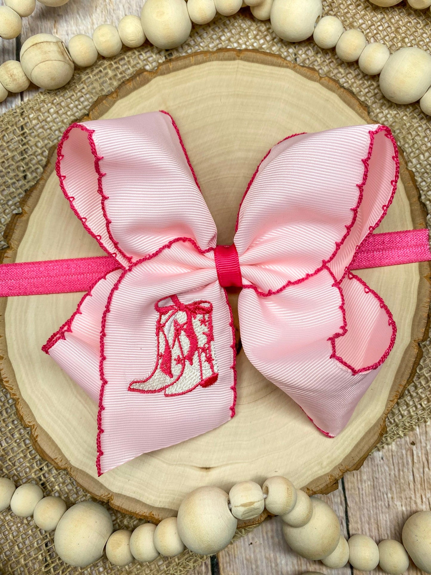 Pink Western Boot Embroidered Moonstitch Headband on a wooden background
