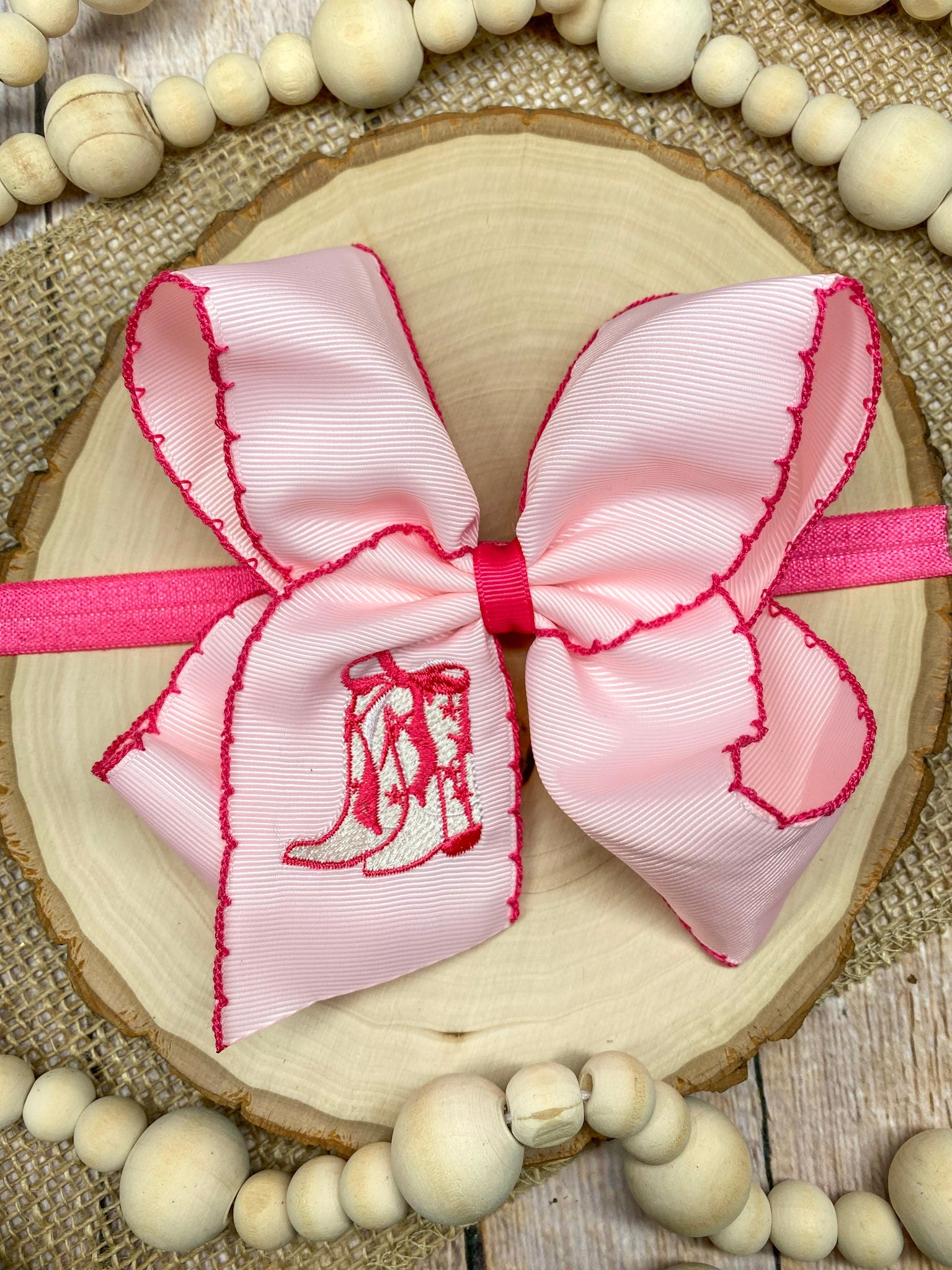 Pink Western Boot Embroidered Moonstitch Headband on a wooden background