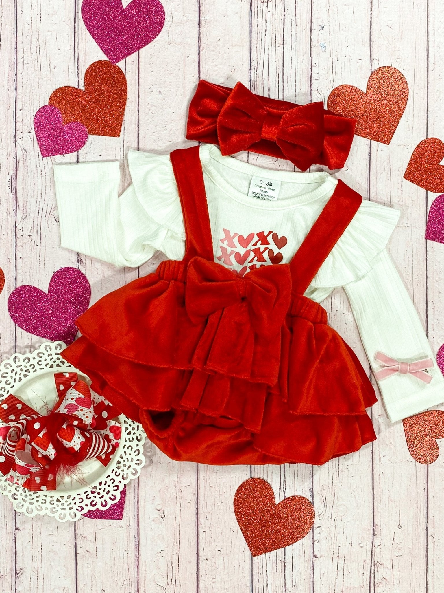 XOXO Valentine infant romper set with white trim, featuring a ruffled skirt from The Hair Bow Company