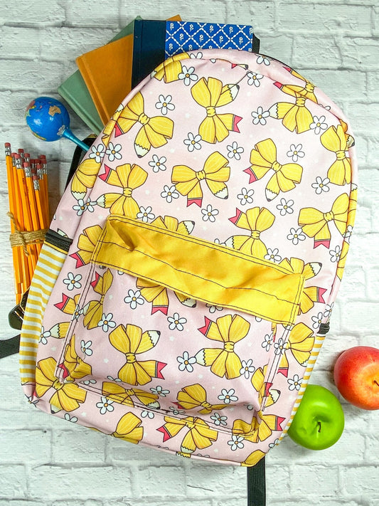 Yellow backpack with a pencil and bow print